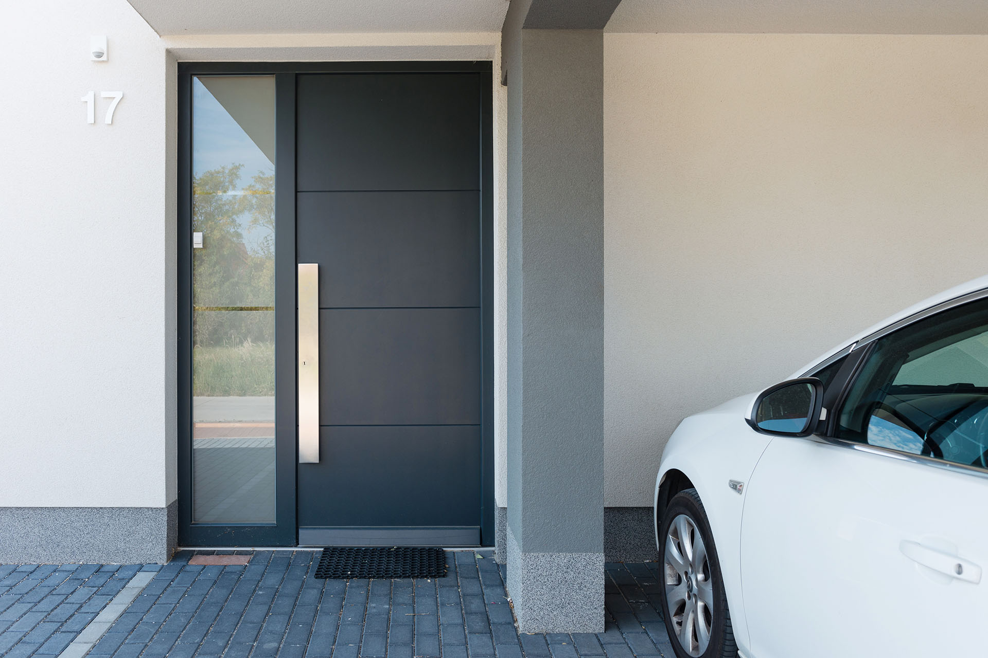 Modern house entrance with parking car next to it